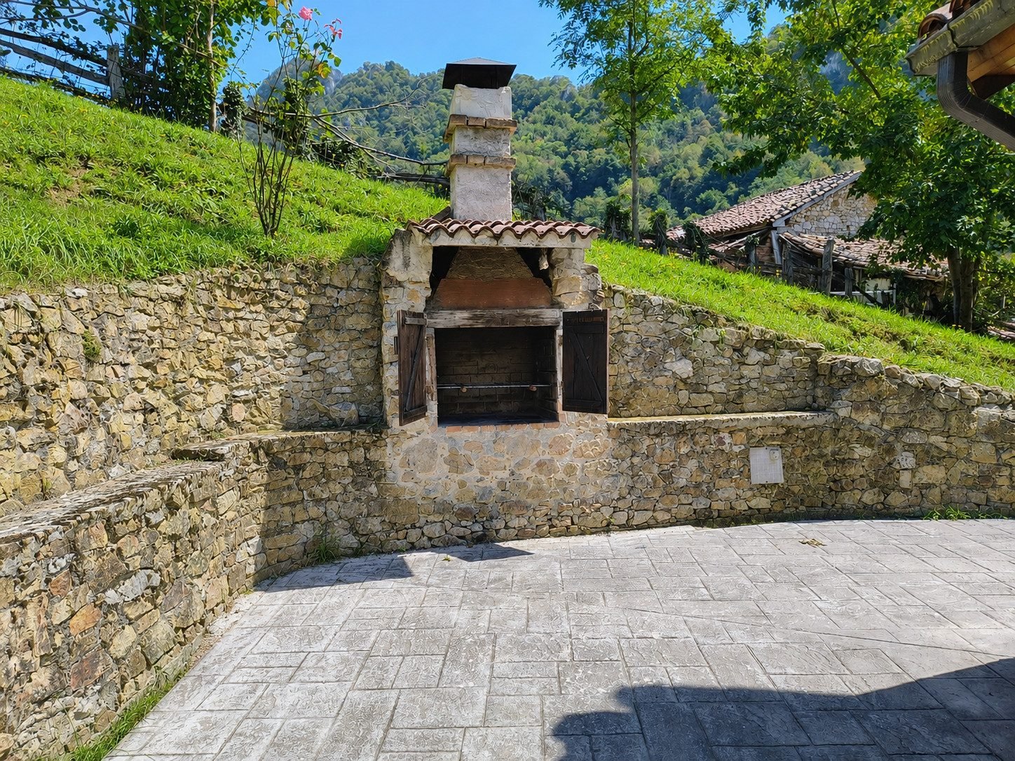 Barbacoa de piedra en la terraza, con el valle al fondo